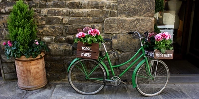 Eine Radtour in der Toskana von Pisa nach Florenz Ein grünes Fahrrad an einer Mauer