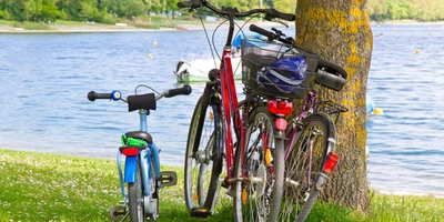 Fahrradausflug mit Kindern: Das passende Rad Fahrräder stehen in der Nähe eines Sees