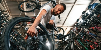 Mann repariert E-Bike in einem Fahrradgeschäft.