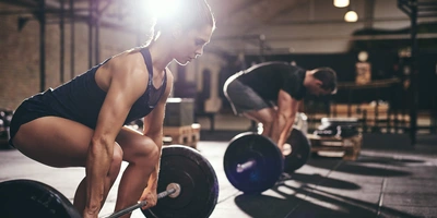 Mann und Frau trainieren Kreuzheben im Fitnessstudio