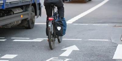 Fahrradfahrer fährt mit eingeschaltetem Rücklicht durch Straßenverkehr