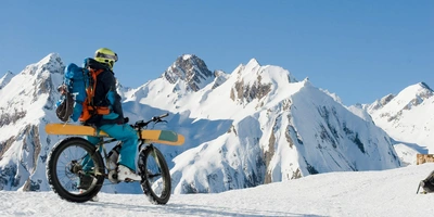 Skier fürs E-Bike - nachhaltig auf der Piste Ein E-Bike Fahrer fährt im Schnee mit seinen Skiern