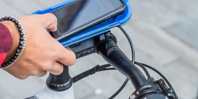 Smartphone befindet sich in einer Halterung am Fahrrad.