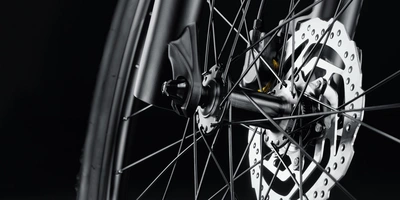 Speichenarten Fahrrad – das musst du wissen Nahaufnahme eines Fahrradbremsen mit Speichen auf schwarzem Hintergrund.