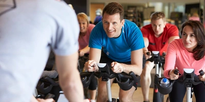 Mehrere Personen machen zusammen Sport auf Spinning-Bikes.