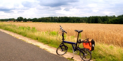 Ein Klapprad am Straßenrand an einem Feld