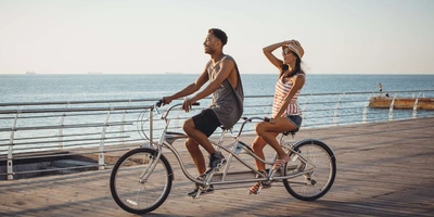 Ein Paar fährt Tandem am Meer. 