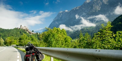 Fahrrad ist abgestellt auf einem Radweg vor österreichischer Landschaft