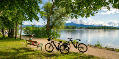 Pause von zwei Fahrradfahrern neben einer Bank am Tegernsee