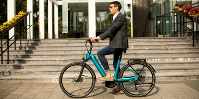 Junger Geschäftsmann sitzt auf E-Bike.