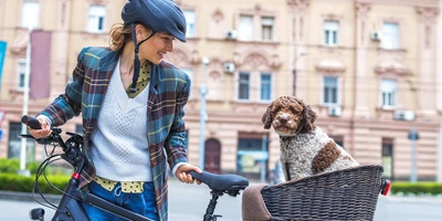 Frau transportiert ihren Hund mit dem Fahrrad