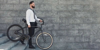 Ein Mann hält in seiner linken Hand sein Fahrrad fest.