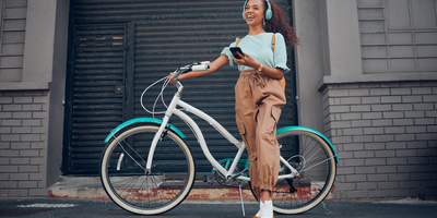 Frau steht vor ihrem Urban-Fahrrad in der Stadt.