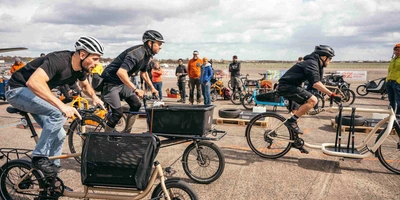 Personen fahren auf der Velo Berlin ein Wettrennen mit Lastenfahrrädern