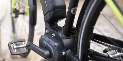 Vergleichstest von Motorkonzepten bei Elektrofahrrädern Ausschnitt eines E-Bikes, auf dem Akku und Mittelmotor sichtbar sind.