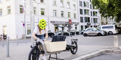 Frau sichert Lastenrad