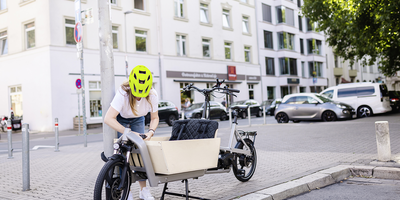 Frau sichert Lastenrad