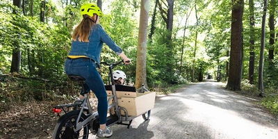 Mit Dienstrad-Leasing zum Lastenrad Frau auf Lastenrad im Wald