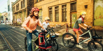 Woom Bikes für Kinder und Jugendliche Kinde rund Jugendliche fahren auf Fahrrädern durch die Stadt