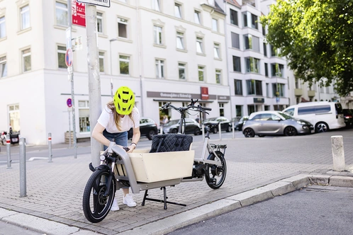 Frau schließt Lastenrad ab