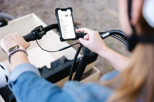 Frau auf Lastenrad benutzt Fahrradpass in der linexo App