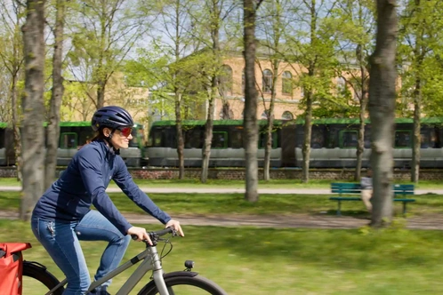 Eva-Maria auf dem Fahrrad mit Helm und Fahrradtasche